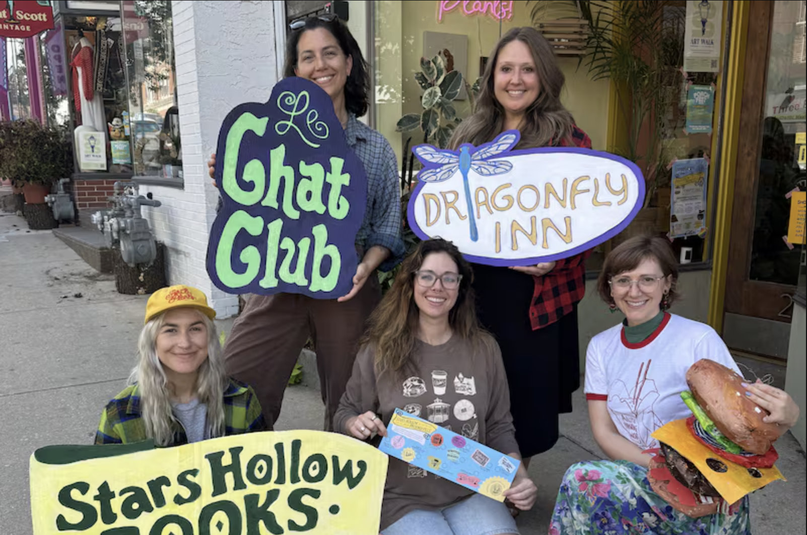 The Phoenixville Stars Hollow crew outside Perch with handmade Gilmore Girls-inspired signs.